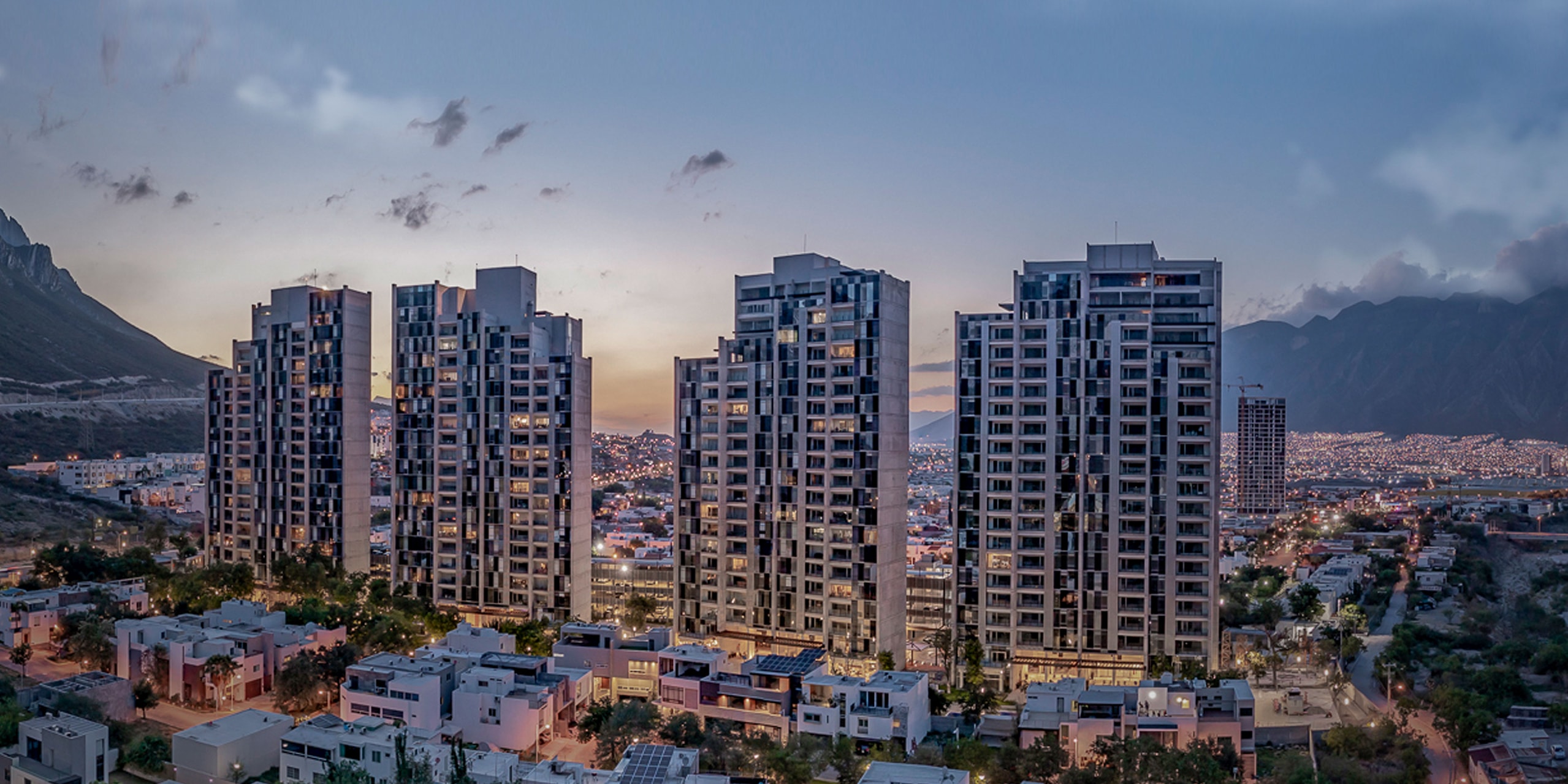 Torres residenciales de Las Huastecas al atardecer, con la sierra de fondo